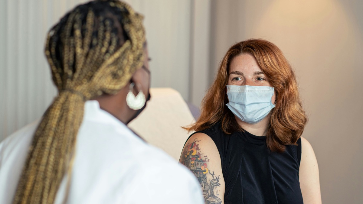 Healthcare provider consulting with young adult patient about medical information in clinical setting