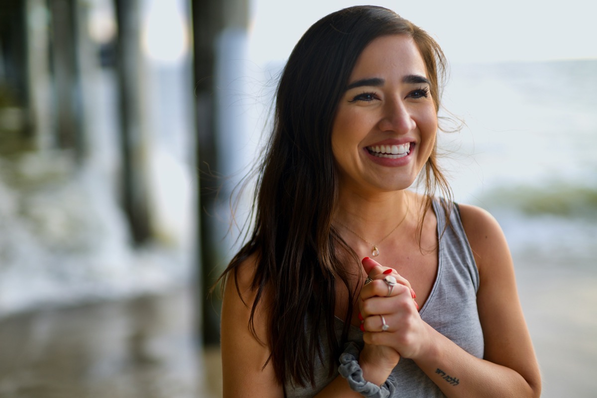Young woman laughing candidly outdoors near the water